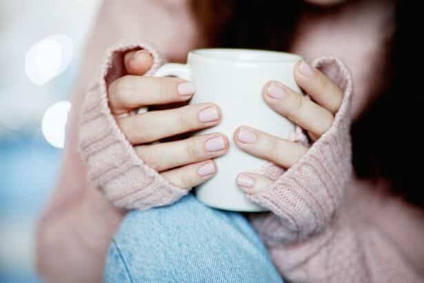 femme tenant tasse de café chaud et porte un pull en laine